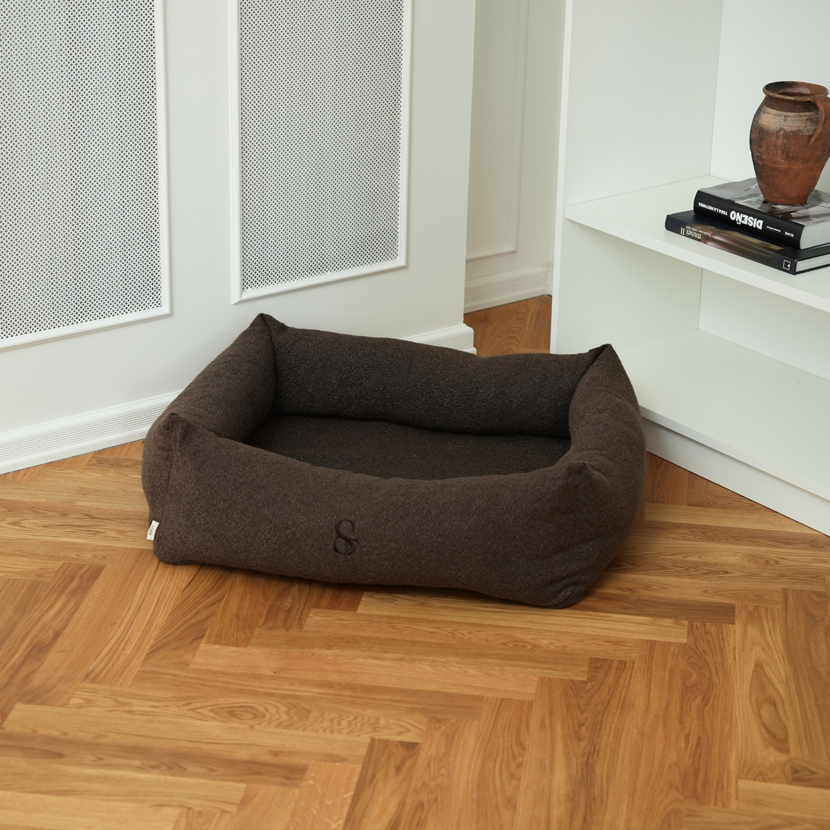 The espresso rectangular dog bed on a parquet floor in a living room