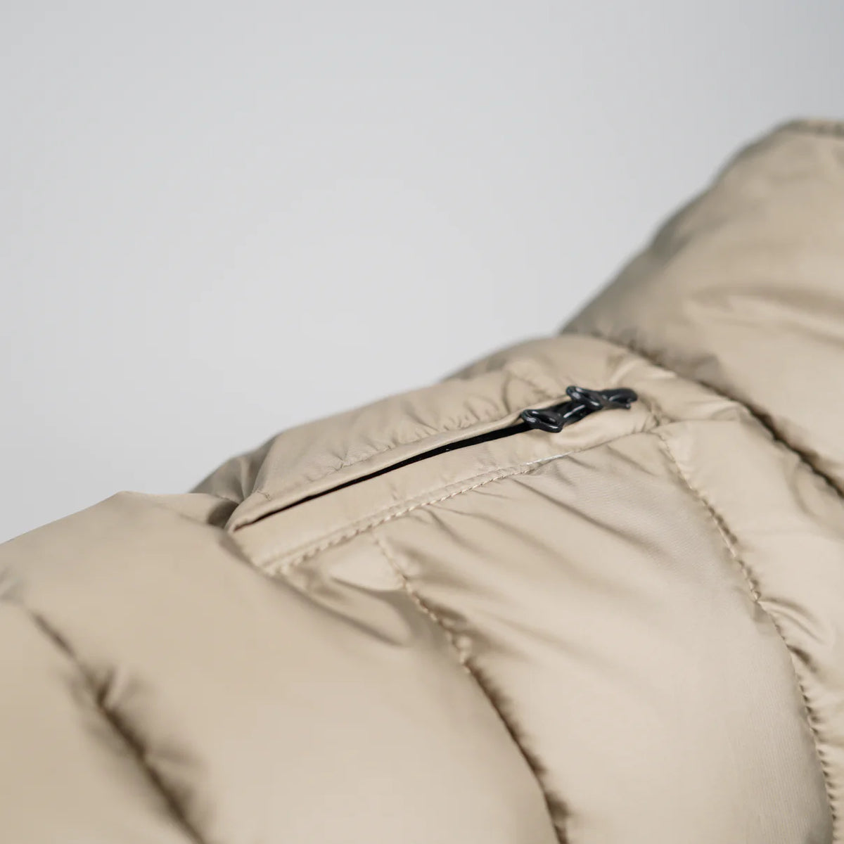 Close-up of the zip pocket on the nature beige quilted dog coat