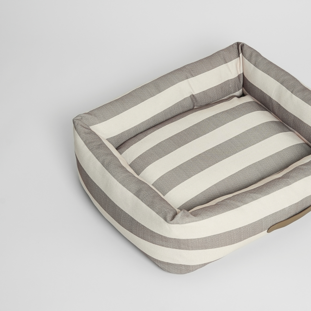 Striped dog bed in taupe and cream, seen at an angle