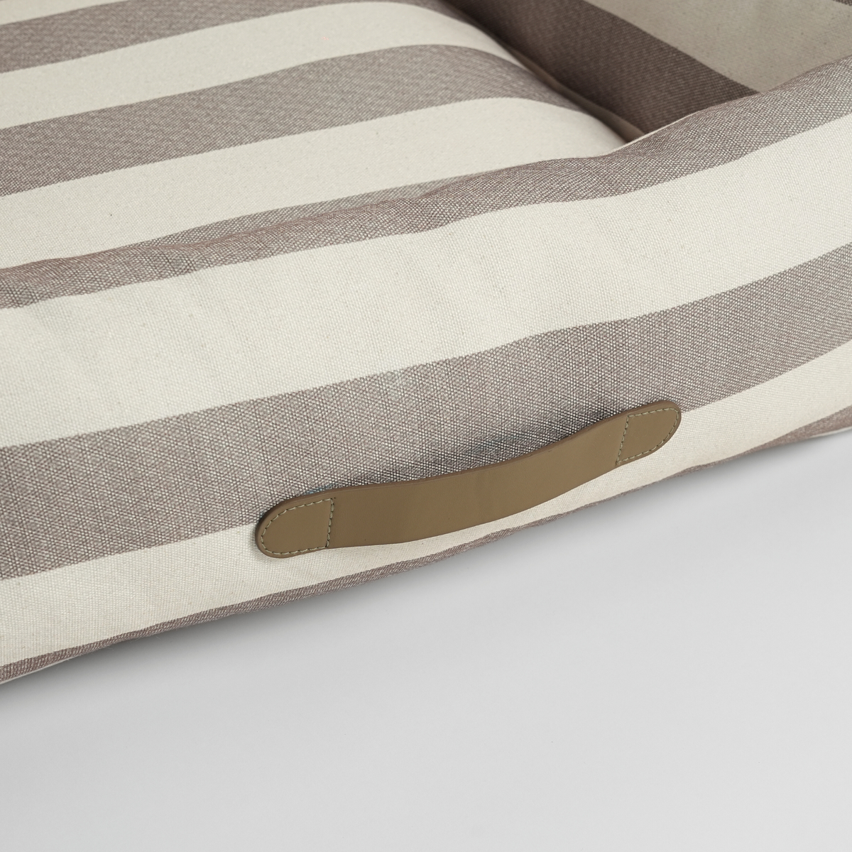 Close-up of the carry handle on the striped dog bed