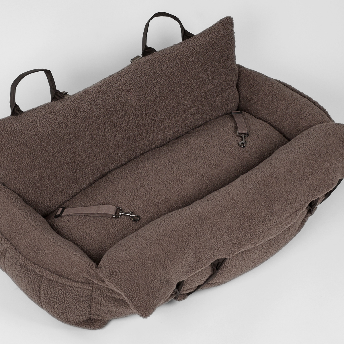 The Clara teddy car seat seen from above with its safety strap