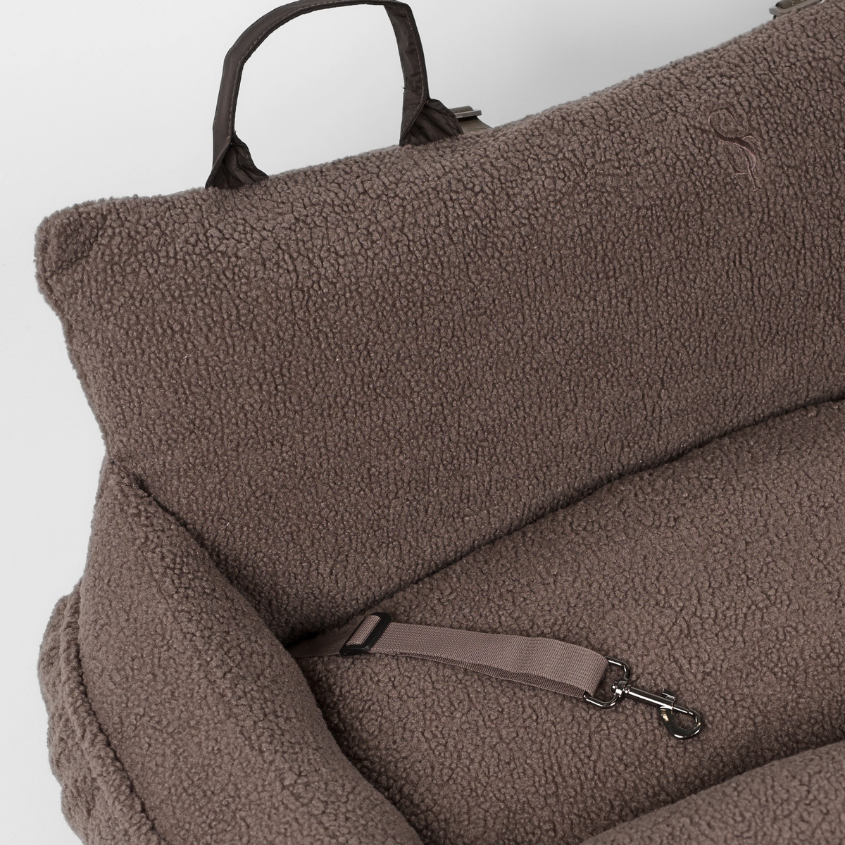 Close-up of the safety strap and cushion inside the Clara teddy car seat