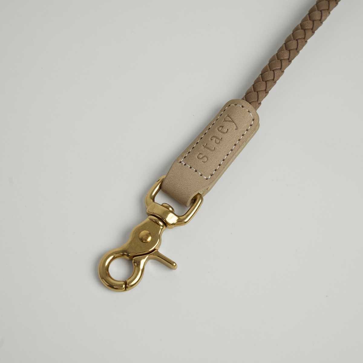 Close-up of the brass hook on the taupe braided leather leash