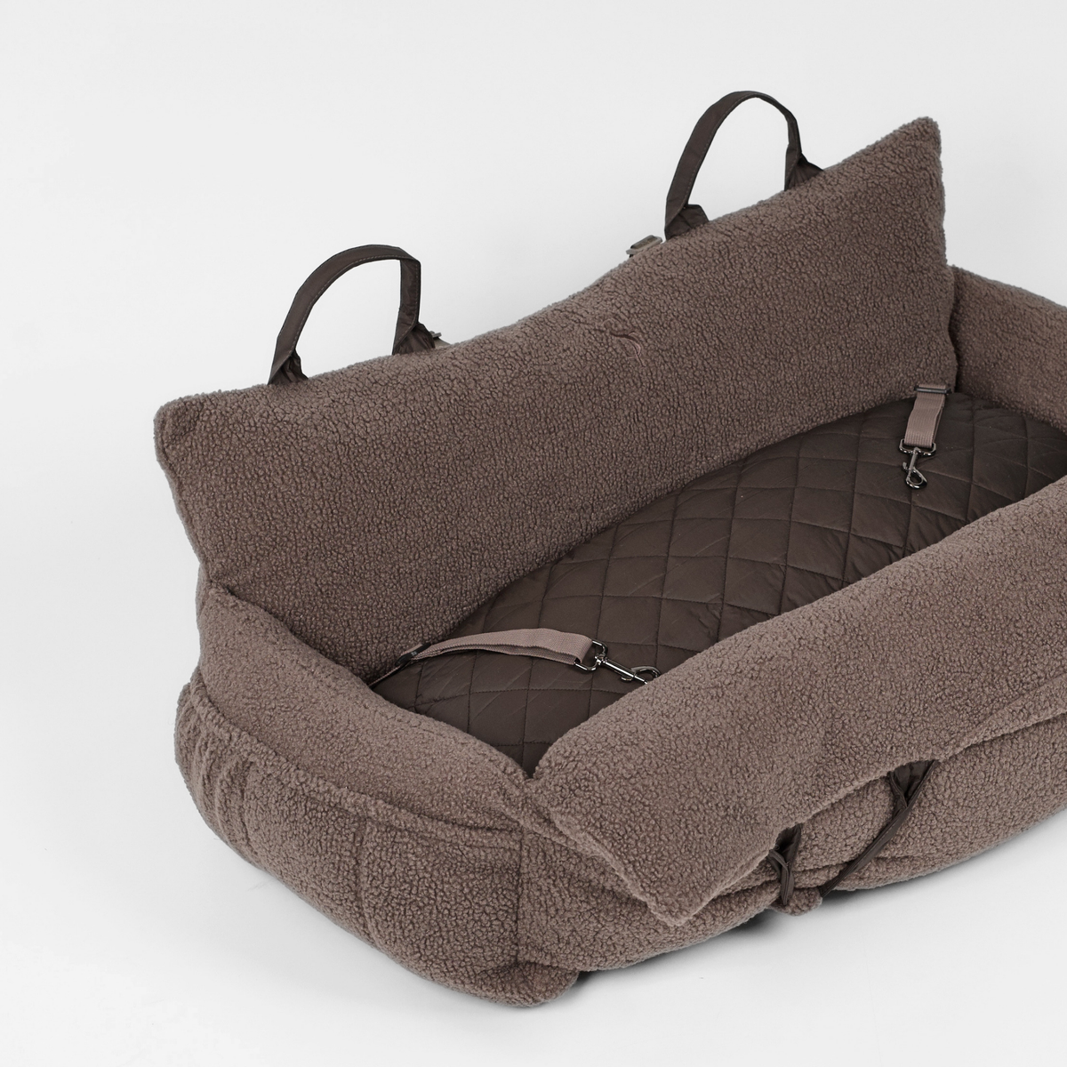 The Clara teddy car seat at an angle, showing its quilted lining