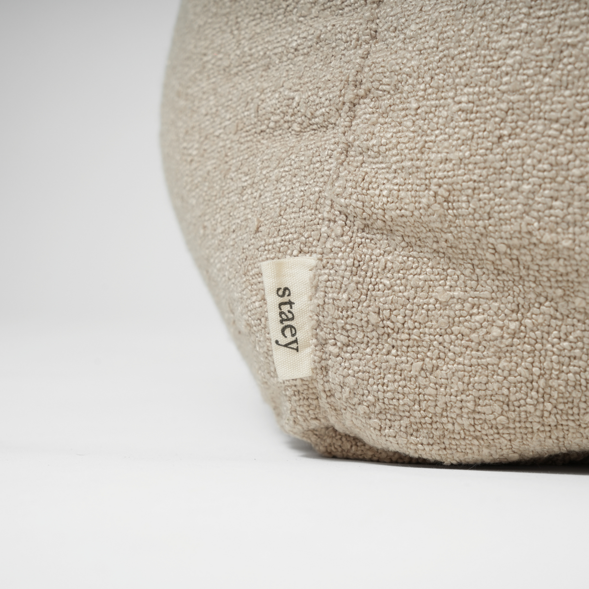 Close-up of the Staey label on the oat bouclé dog bed