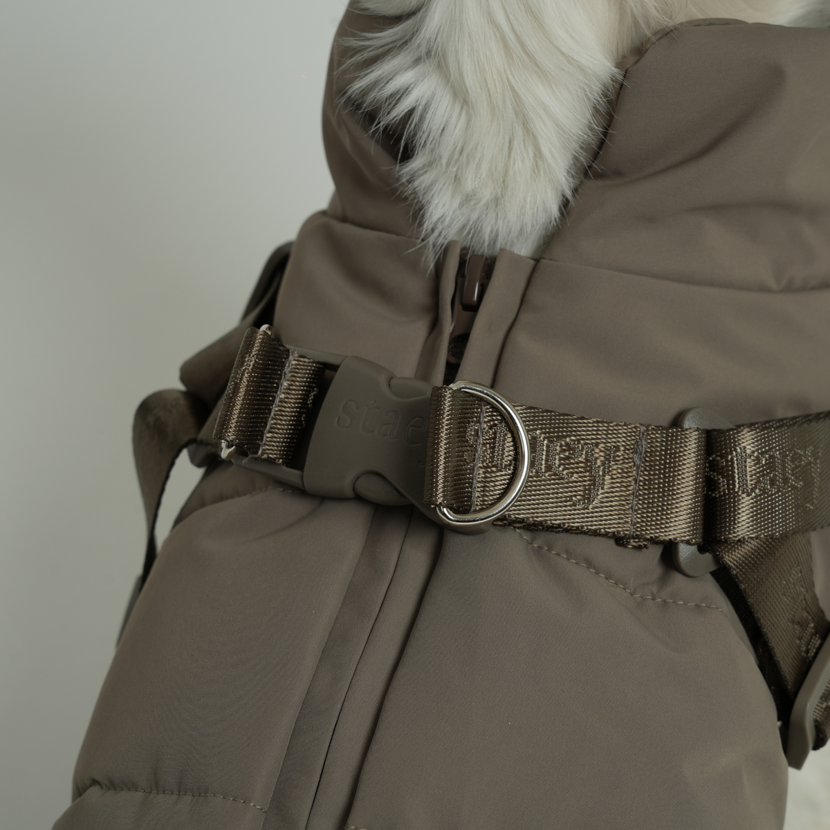 Close-up of the D-ring and belly strap on the moss green quilted coat
