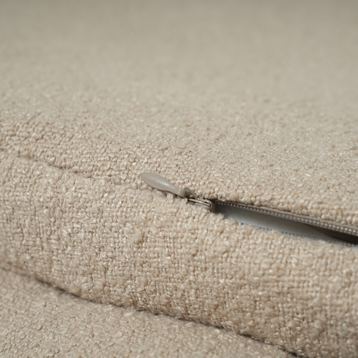 Close-up of the zip on the removable cover of the oat bouclé dog bed