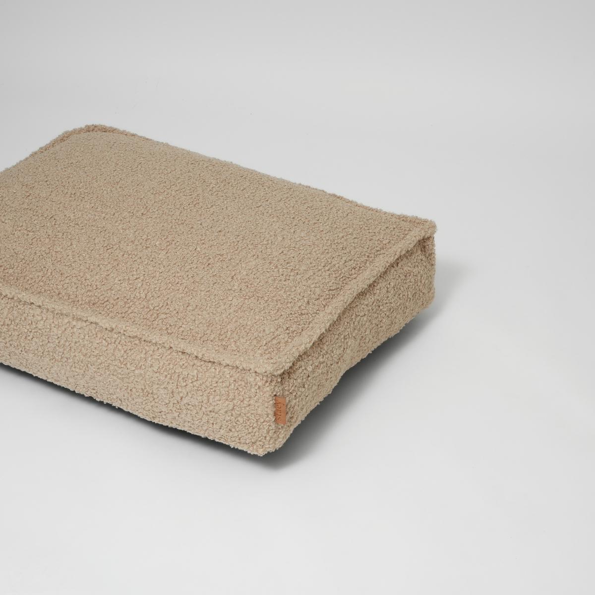 The sand curly bouclé dog mattress seen at an angle