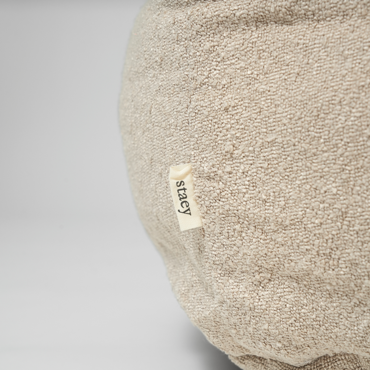 Close-up of the Staey label on the oat bouclé Luna dog bed