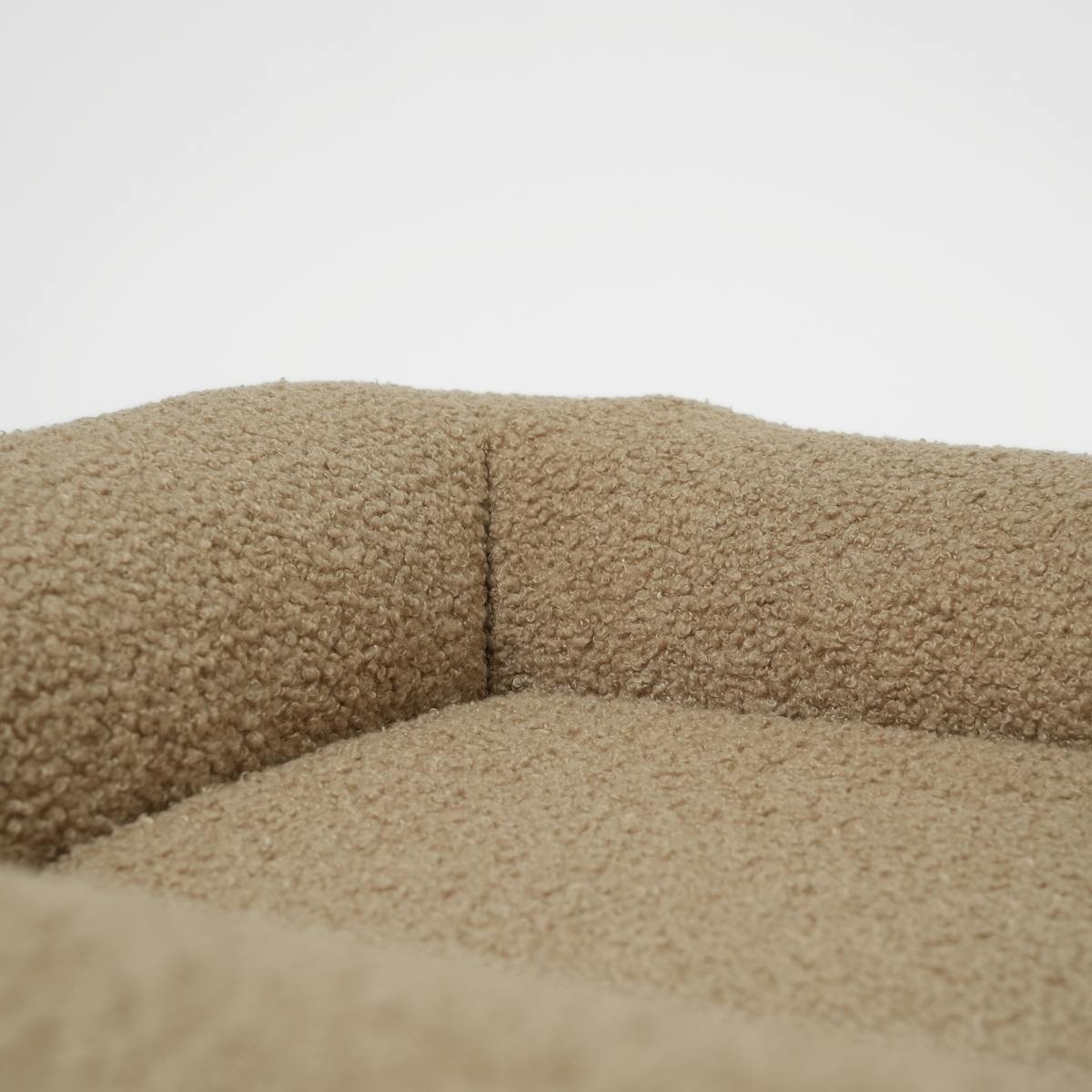 Close-up of the bolster and cushion in the moss curly bouclé dog bed
