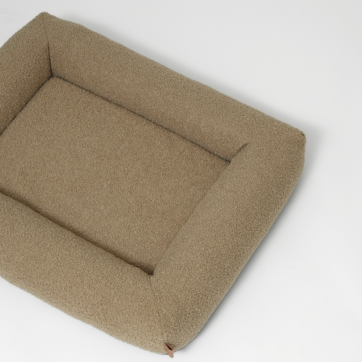 The moss curly bouclé dog bed seen at an angle