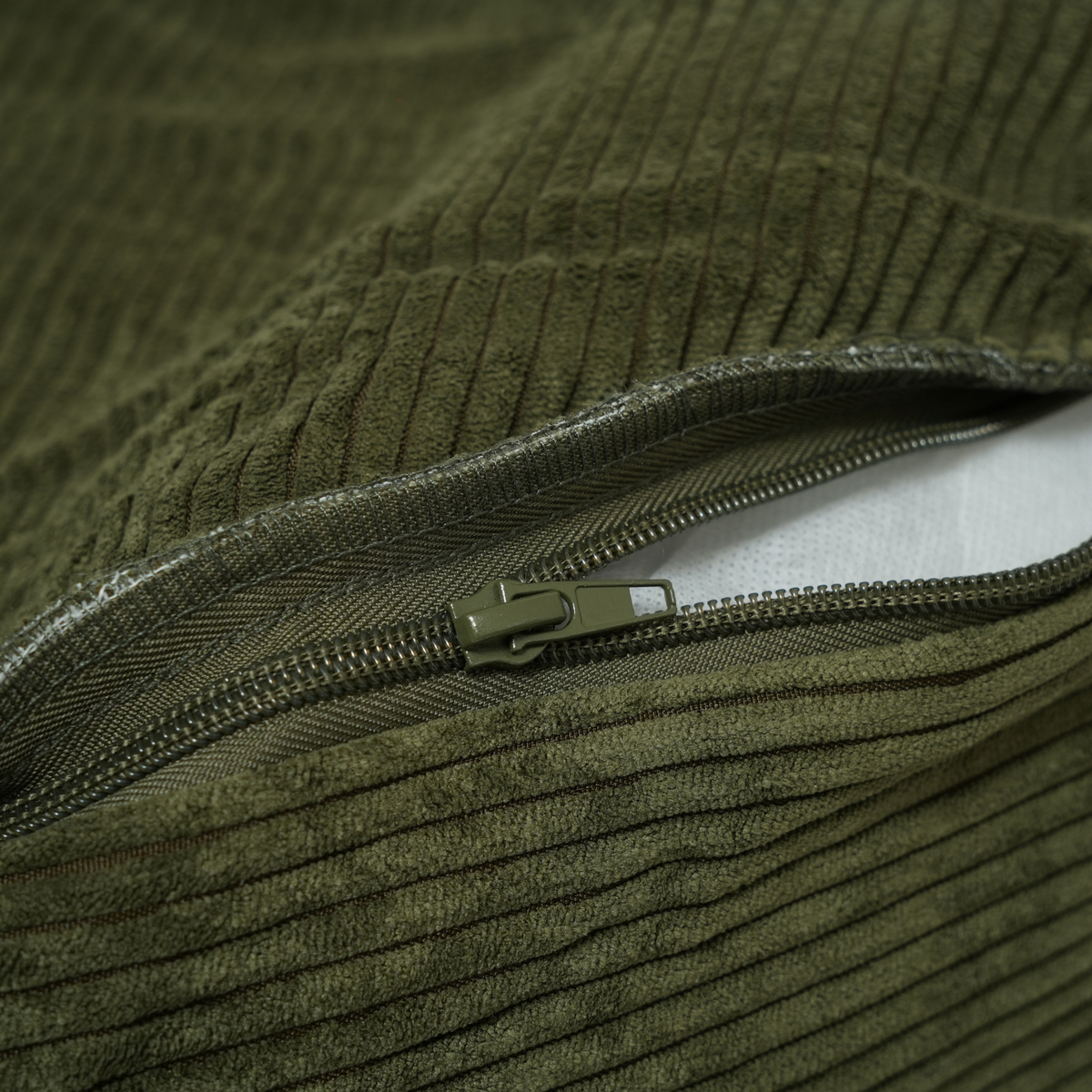 Close-up of the zip on the removable cover of the moss green corduroy dog bed