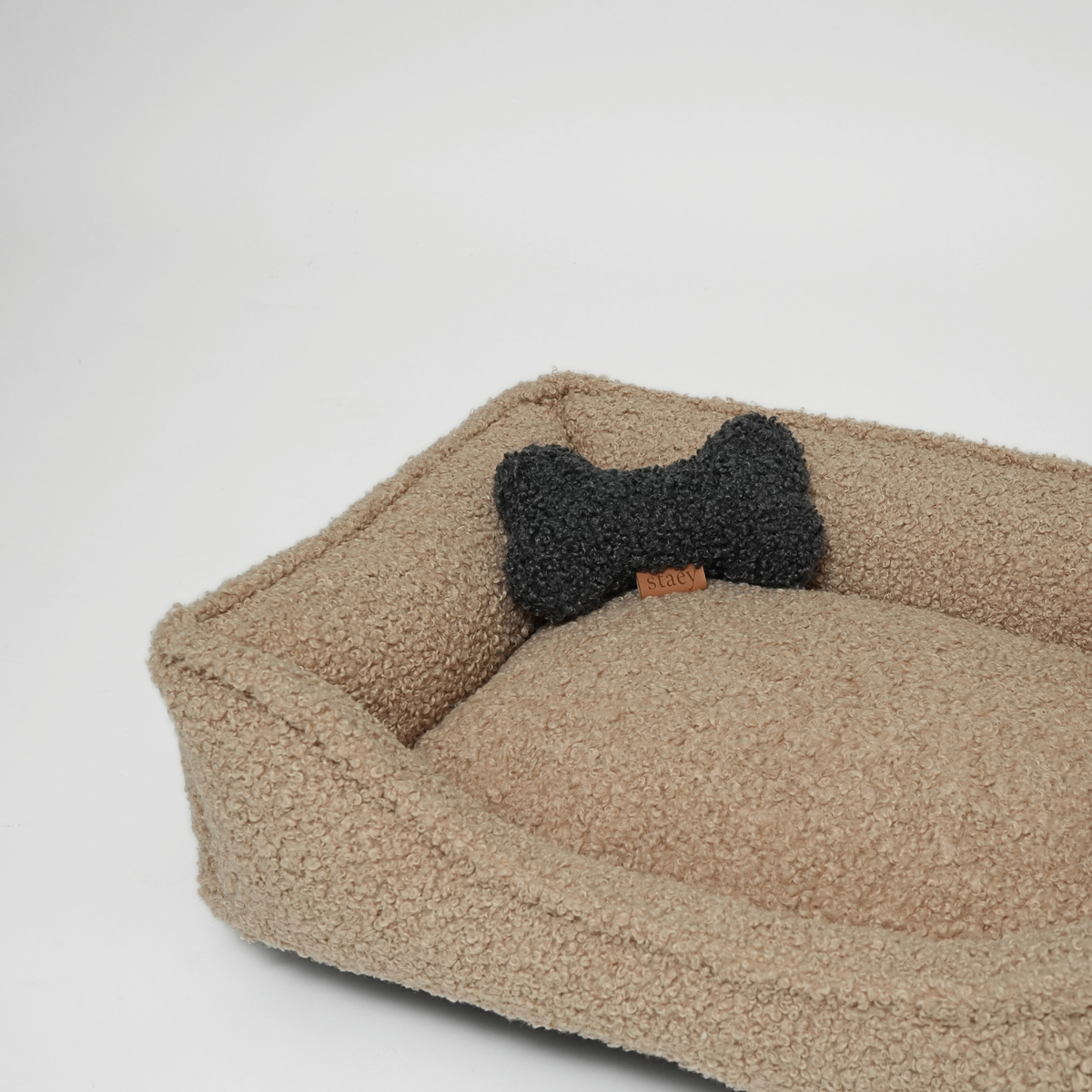 The sand curly bouclé dog bed with a storm bone-shaped cushion