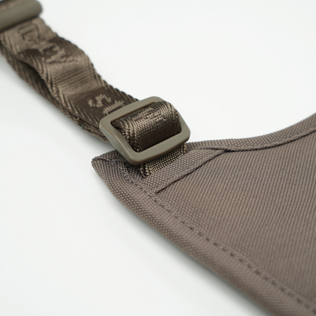 Close-up of the buckle and webbing on the taupe Elma harness