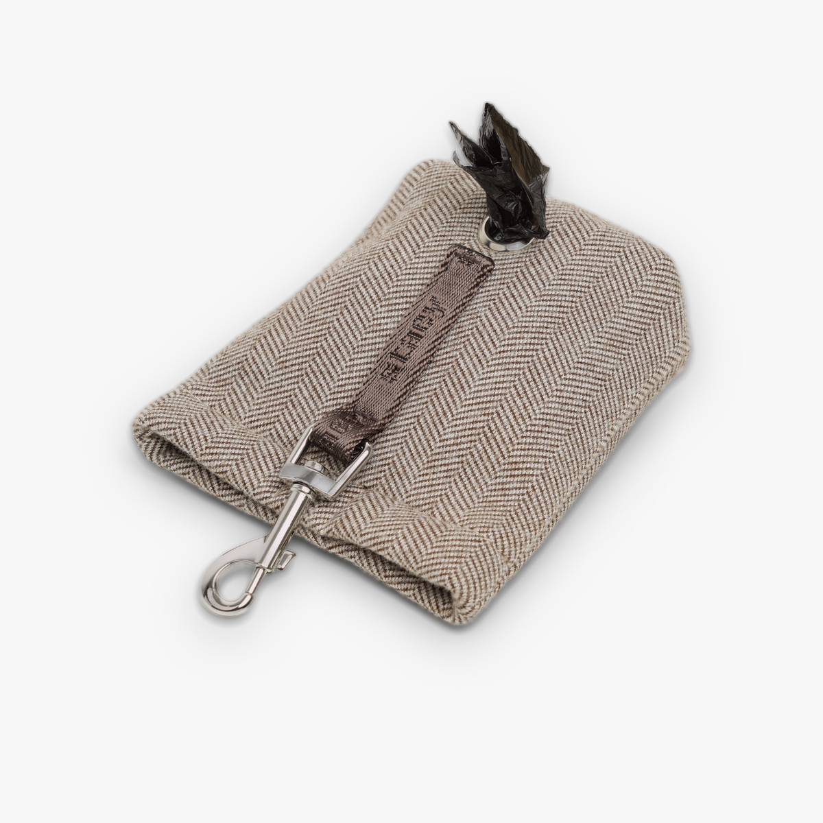 Mocca waste bag holder dispensing a bag from its strap opening
