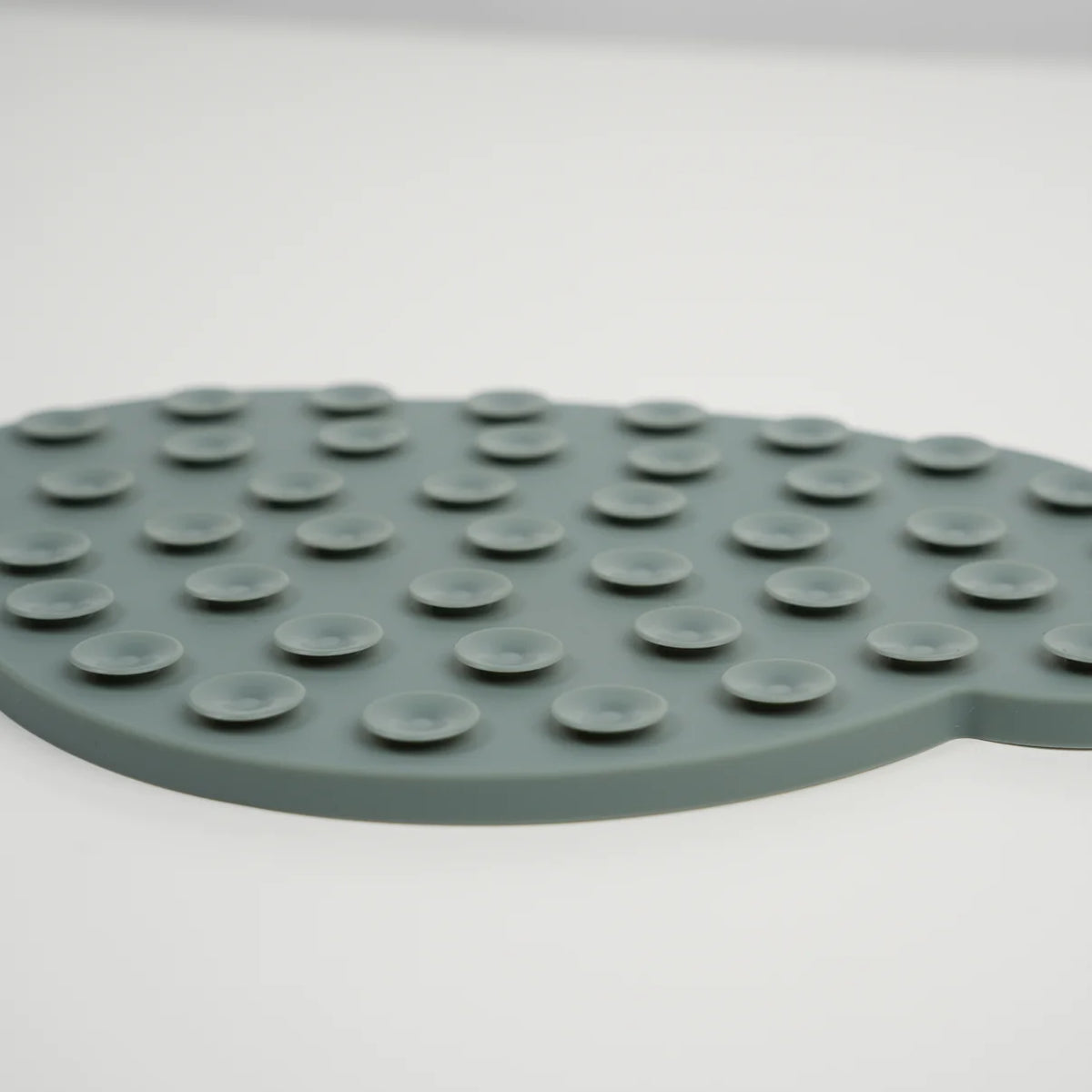Close-up of the suction cups on the back of the moss green licking mat