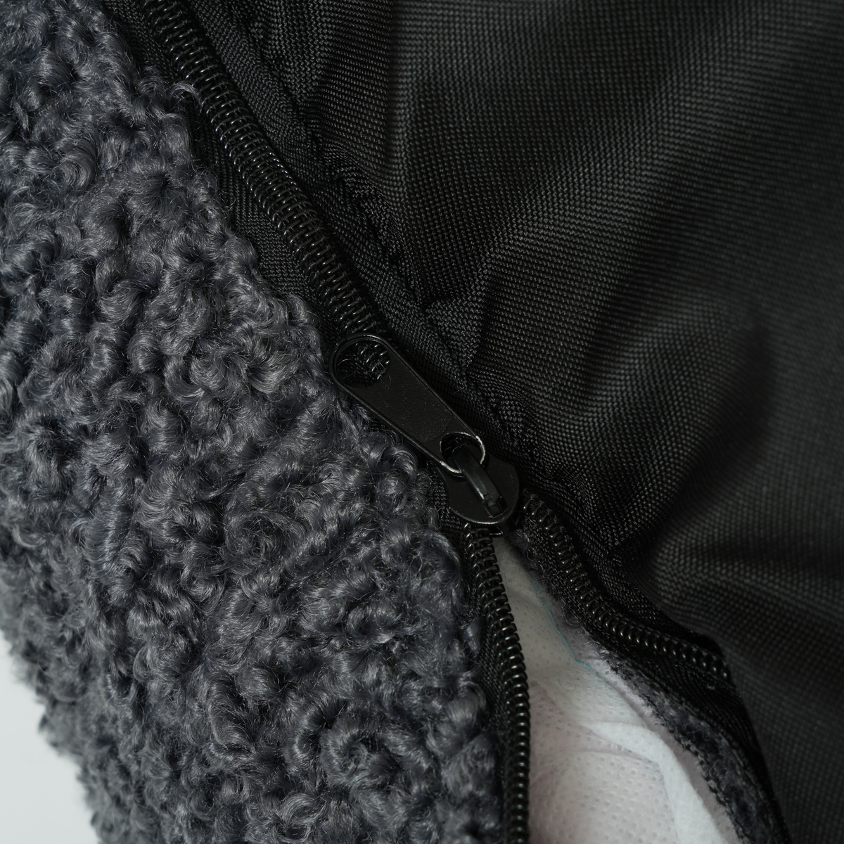 Close-up of the zip and non-slip base on the storm curly bouclé dog bed