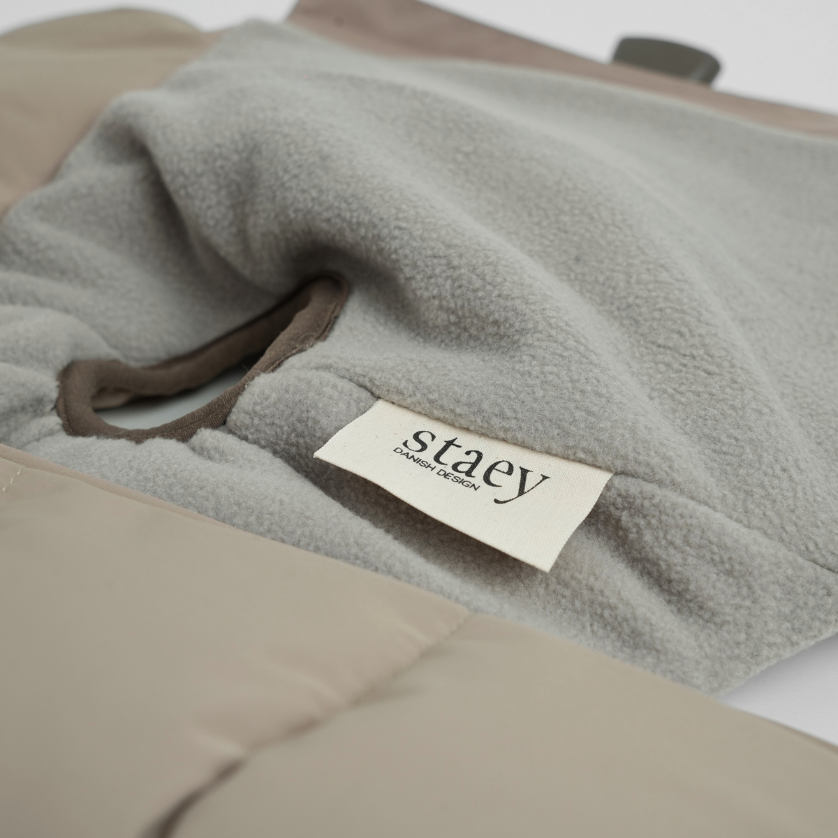 Close-up of the Staey label and fleece lining on a taupe dog blanket