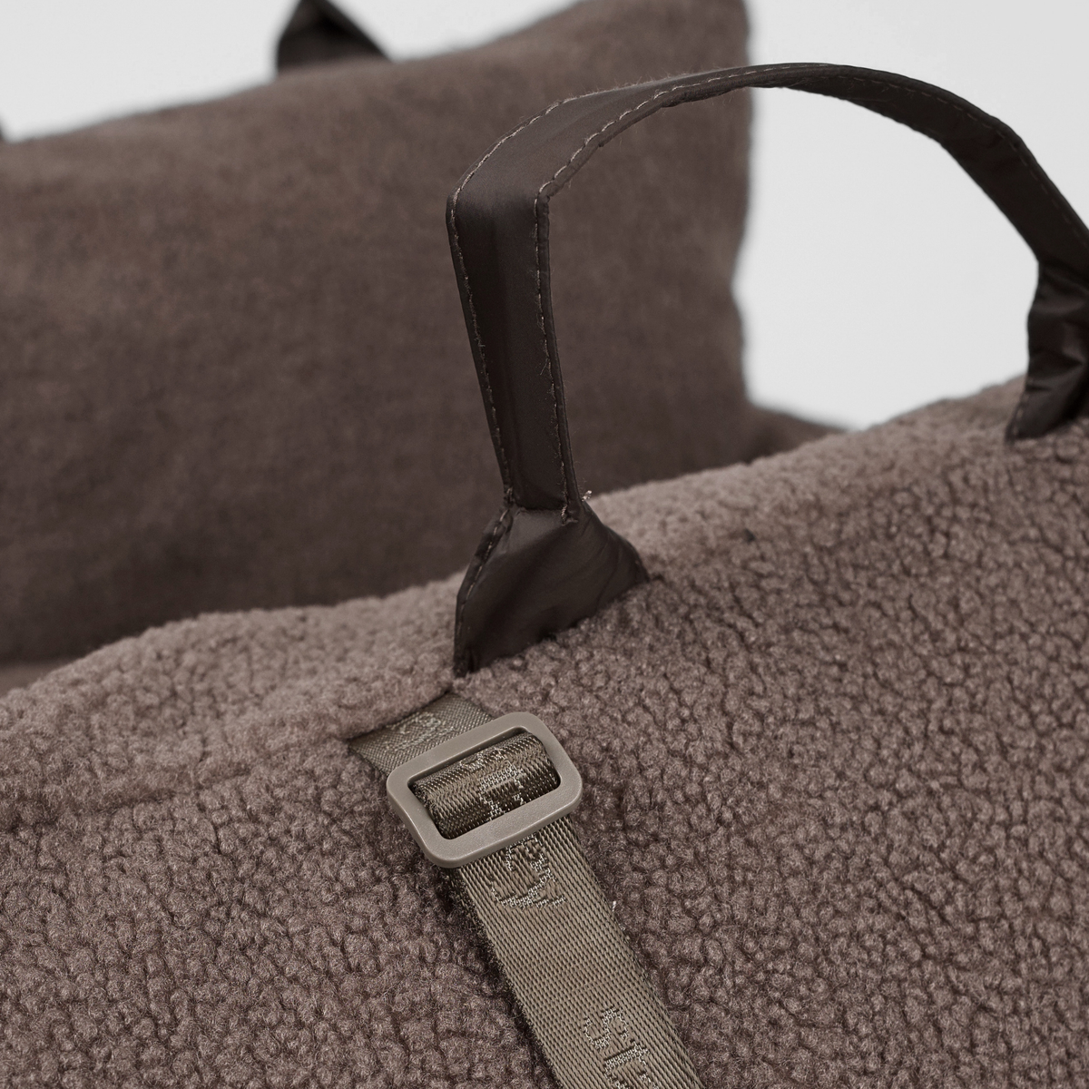 Close-up of the carry handle and buckle on the Clara teddy car seat