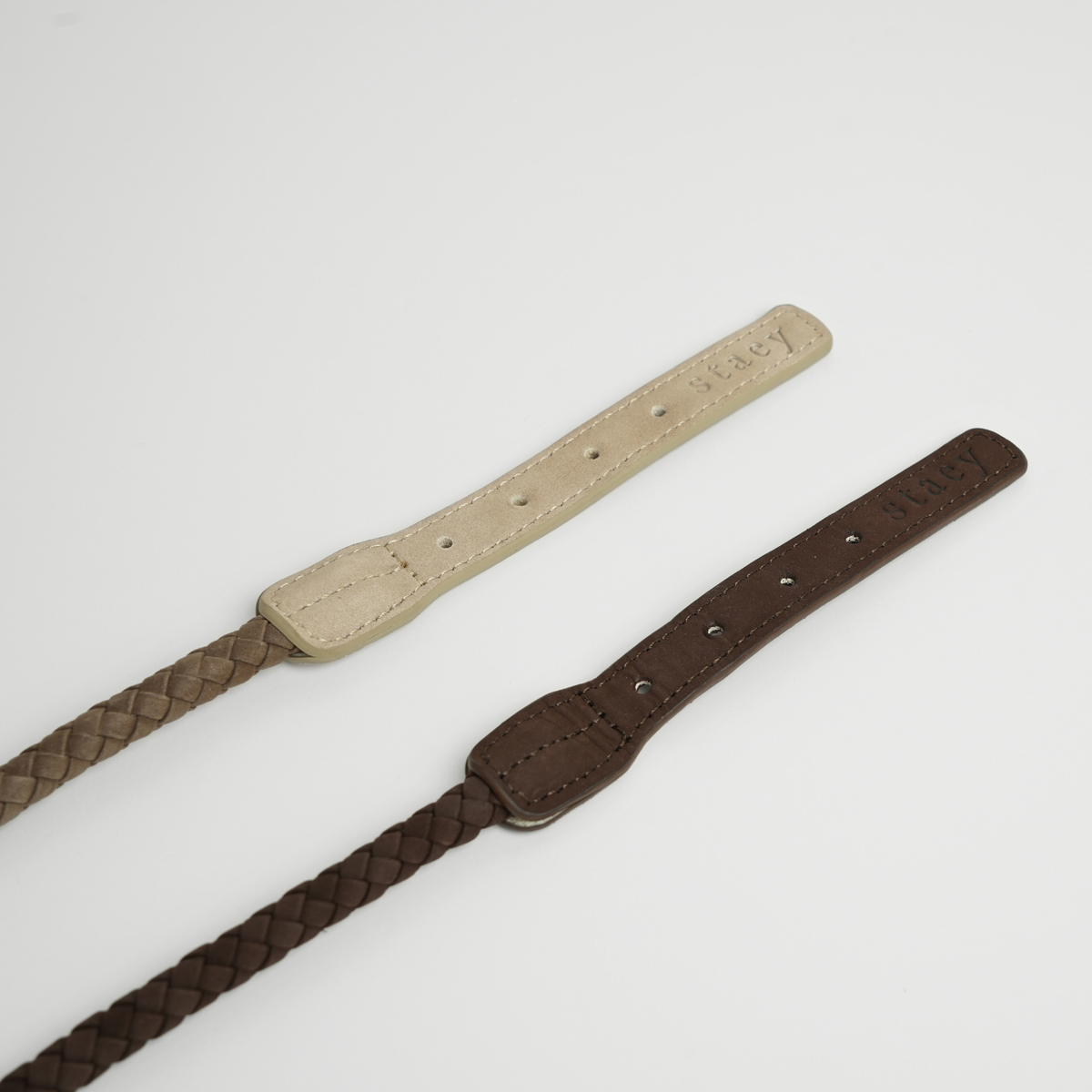 Two leather dog collars in taupe and dark brown, laid flat