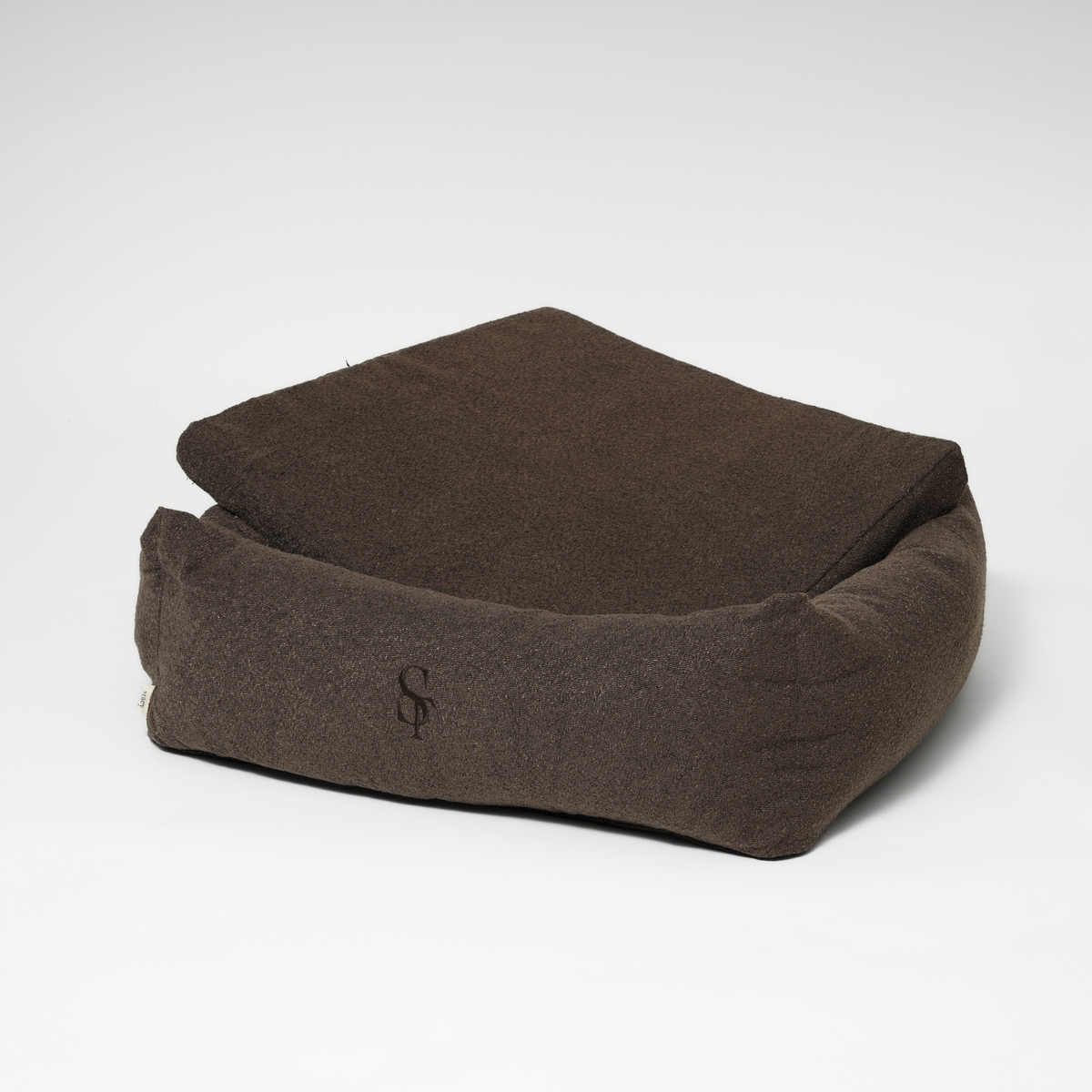 The espresso rectangular dog bed with its cushion propped up