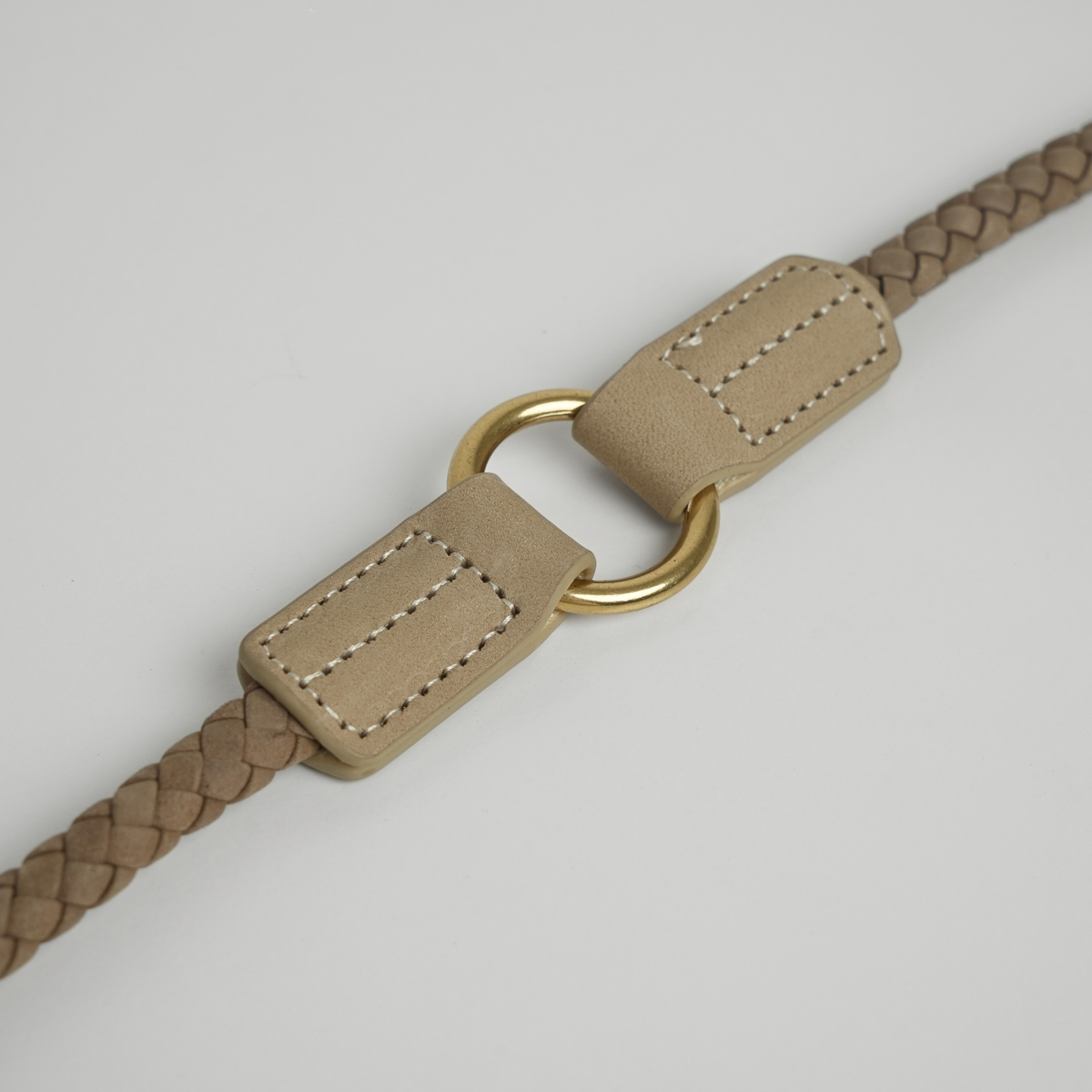 Close-up of the leather tab and D-ring on the taupe braided leash