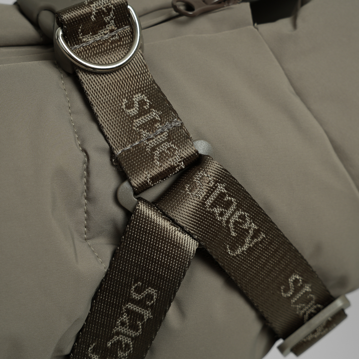 Close-up of the D-ring and Staey webbing on the moss green quilted coat
