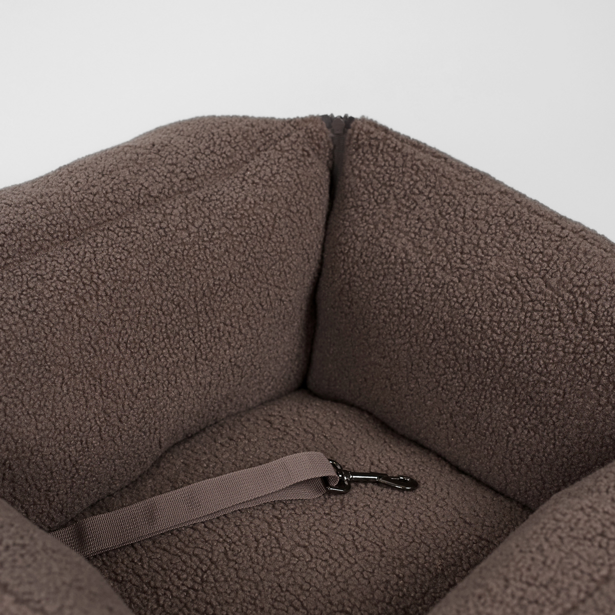 Inside the Clara teddy car seat with its safety strap