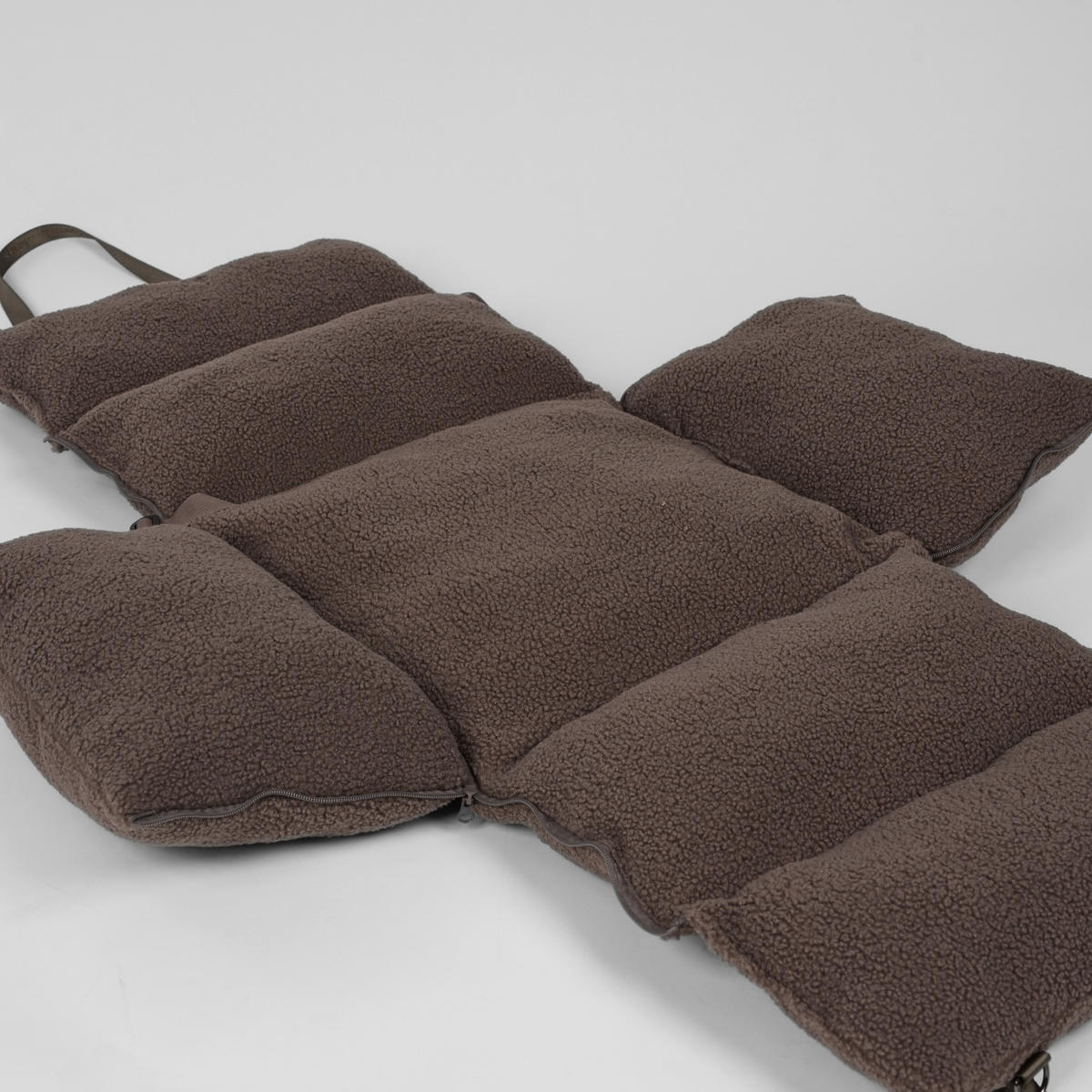 The cover of the Clara teddy car seat unzipped and laid flat