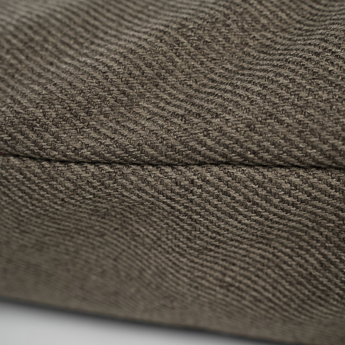 Close-up of the herringbone fabric and seam on a dog cushion