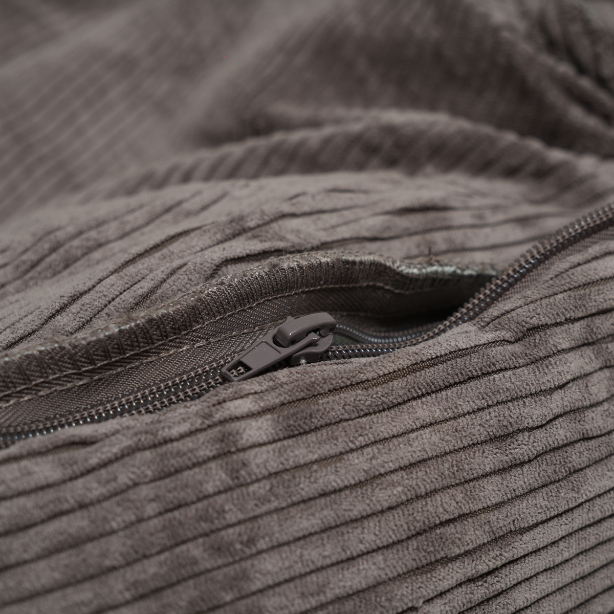 Close-up of the zip on the removable cover of the taupe corduroy dog bed