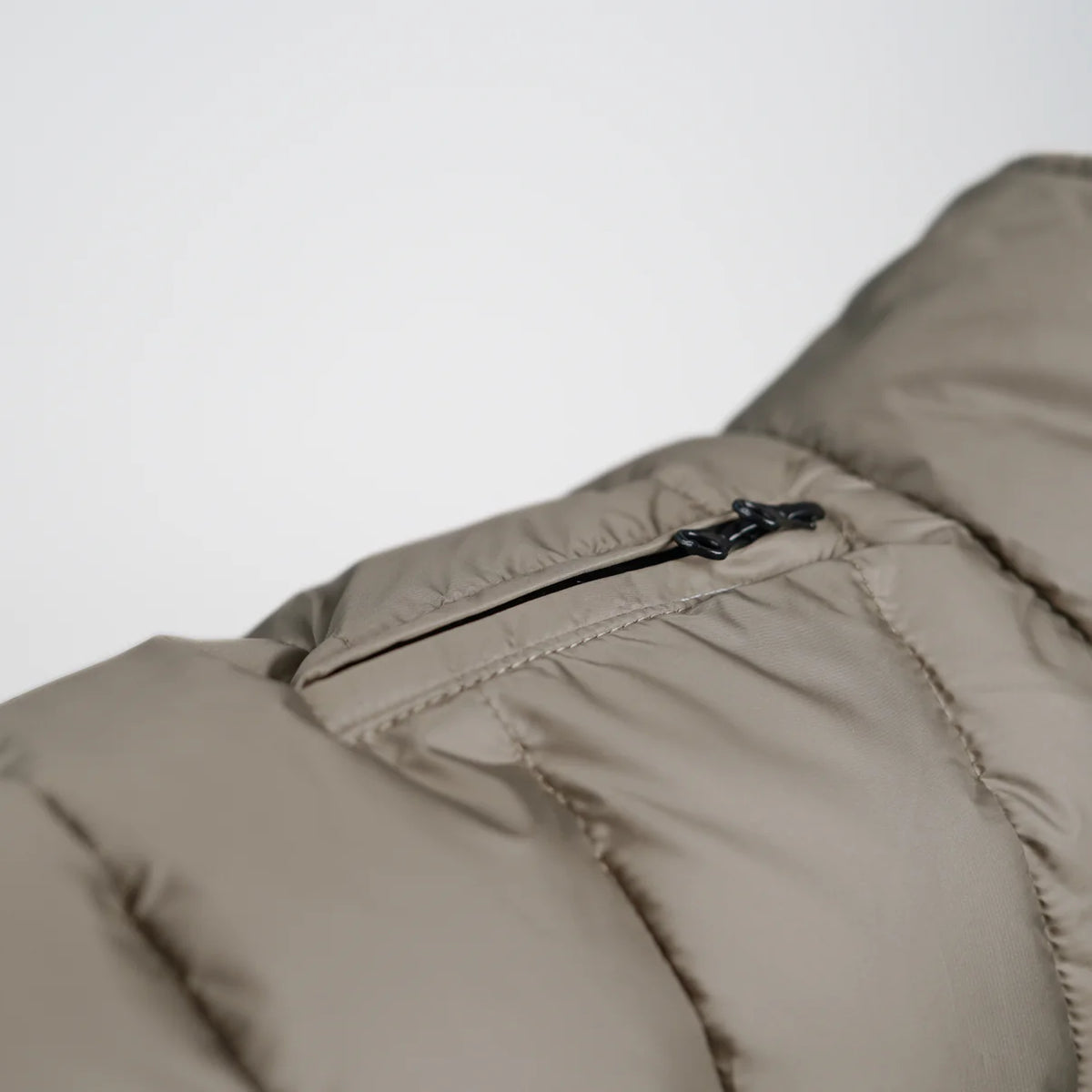 Close-up of the zip pocket on the nature beige quilted coat