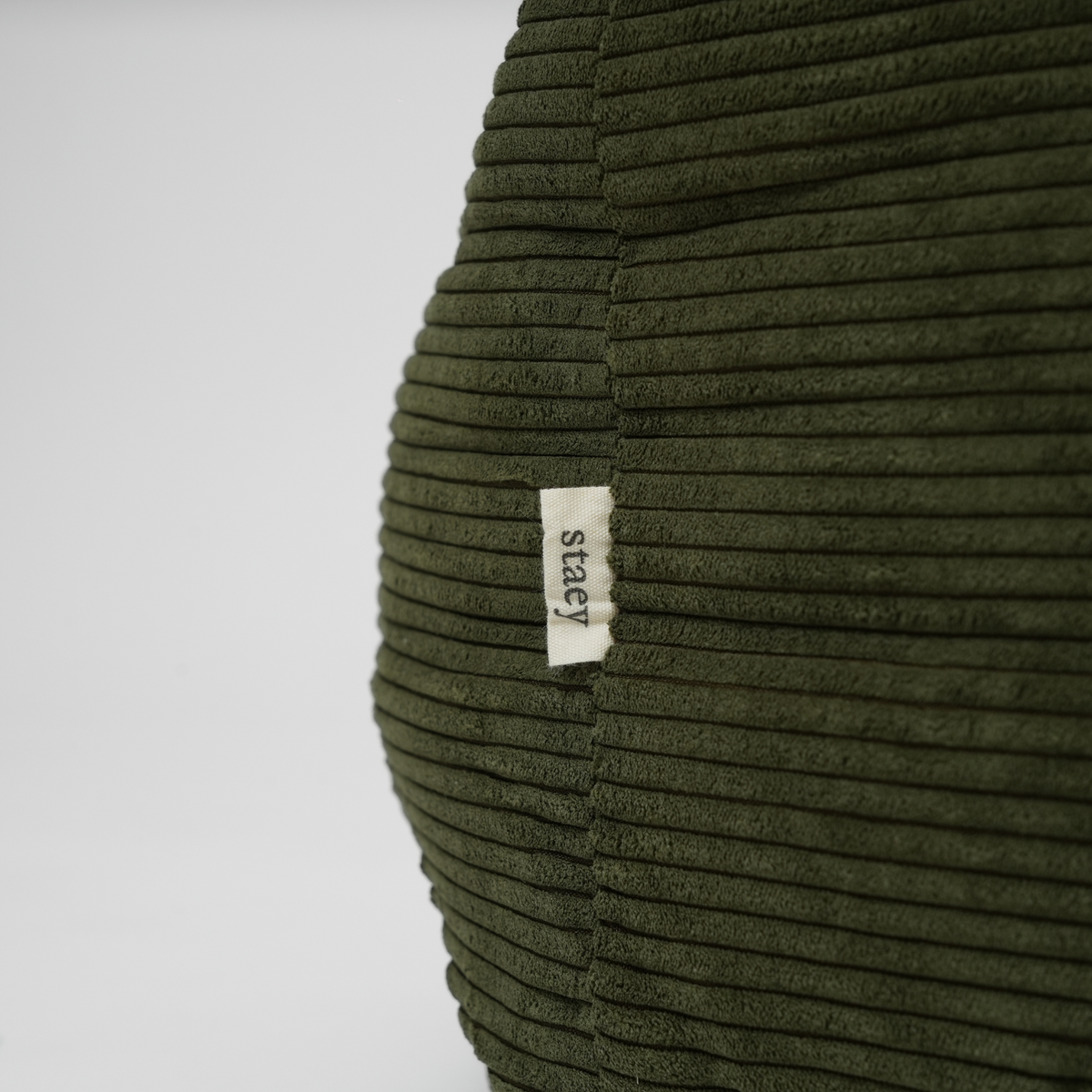 Close-up of the Staey label on the moss green corduroy dog bed
