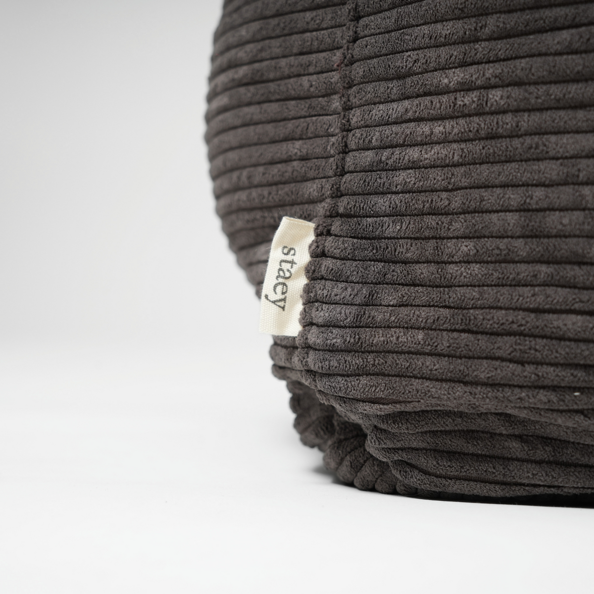 Close-up of the Staey label on the charcoal corduroy dog bed